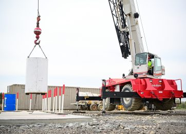 An image depicting a crane operator lifting a heavy load, demonstrating that crane operator requirements are important.