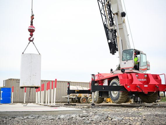 An image depicting a crane operator lifting a heavy load, demonstrating that crane operator requirements are important.